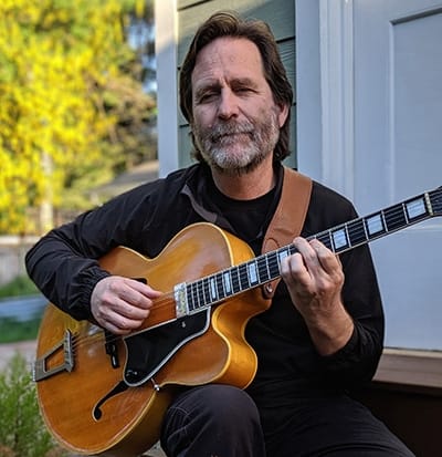Bio photo of Tim Lerch with archtop guitar